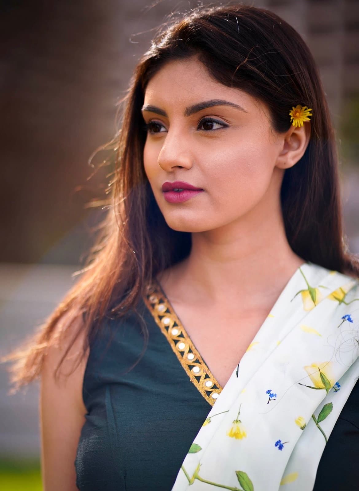 Sarina Agarwal, golden-hour portrait in a deep green dress with a yellow flower in her hair